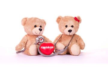 Teddy bears, Covid-19 words on red heart and stethoscope with blackboard on a white background. Health concept. Stop Novel Coronavirus outbreak covid-19 2019-nCoV symptoms in the world.