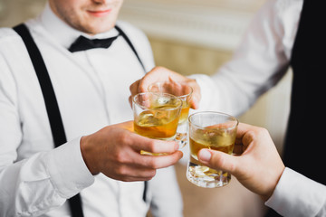 Business meeting. Men hold glasses of whiskey. Men's Party. Hand with a drink of alcohol