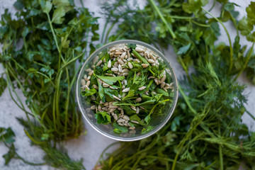 Fresh green pesto with sunflower seeds, dill, parsley, mint in glass blender jar.