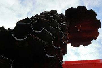 Black metal discs cultivator against the sky. Cultivator for cultivating the land.
