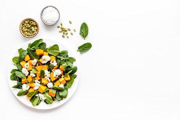 Healthy food concept. Salad with pumpkin and basil on white background top-down copy space