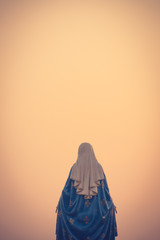 The blessed Virgin Mary statue figure in a warm tone - sunset scene. Catholic praying for our lady...