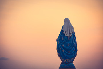 The blessed Virgin Mary statue figure in a warm tone - sunset scene. Catholic praying for our lady...