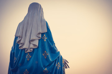 The blessed Virgin Mary statue figure in a warm tone - sunset scene. Catholic praying for our lady...