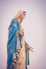 The blessed Virgin Mary statue figure in a sunset time. Catholic praying for our lady - The Virgin Mary.