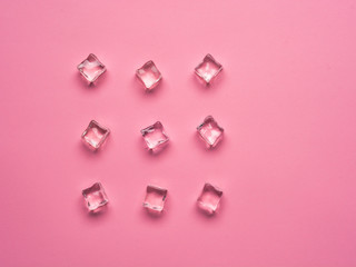 Ice cubes on pink background. Flat lay