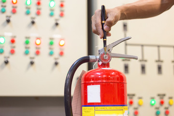 Naklejka premium Technician checking red fire extinguishers available in fire emergencies,safety concept.