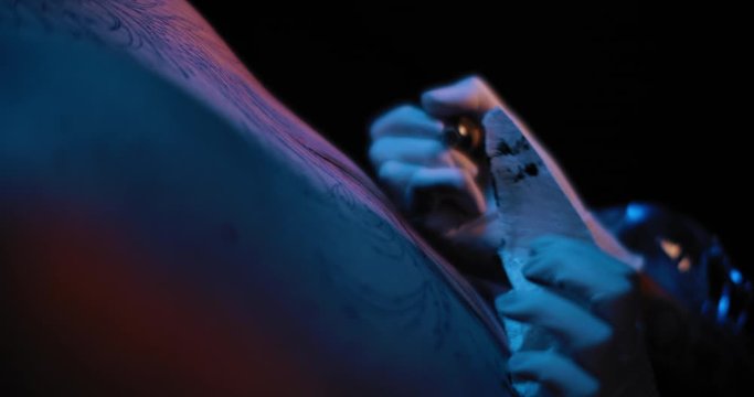 Close up of tattoo artist's hand drawing a tattoo on a person's skin. BMPCC 4K