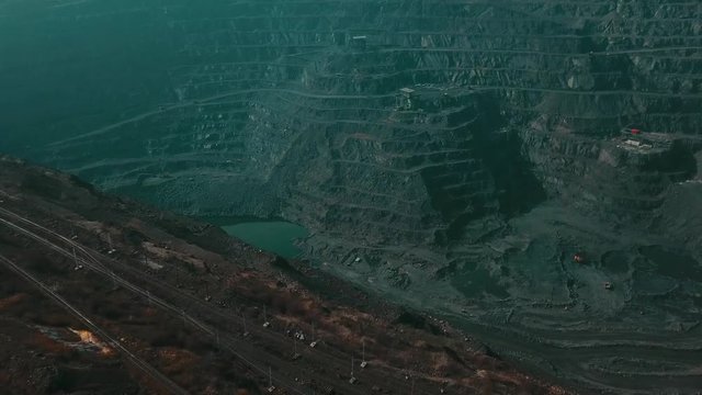 Panorama aerial view shot open pit mine coal mining, dumpers, quarrying extractive industry stripping work. Big Yellow Mining Trucks. View from drone at opencast mining with lots of machinery trucks