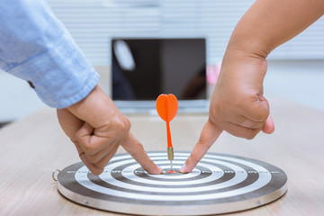 Businessman holding a darts aiming at the target center business goal concept