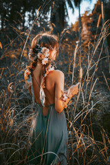 young and tender woman on a feild at sunset portrait