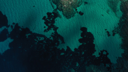 Aerial view of Aegean sea, turquoise water surface, Vourvourou beach, Kavourotripes beach, Sithonia peninsula, Halkidiki, Greece. Rocks, stones underwater.