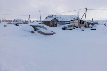 Teriberka, Murmansk region / Russia - 02.19/2020: Cars swept by snow in the old fishing village of...