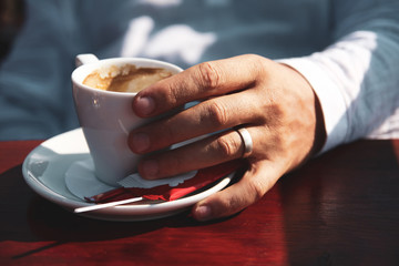 Close up of man hands holding a cup of coffee
