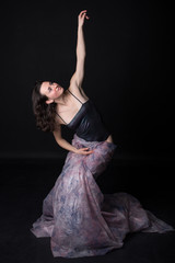 Fototapeta premium dancer in bodypiece with long scarf in front of black background