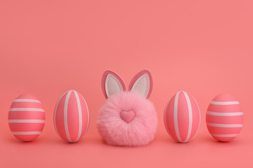 Monochrome Easter. Pink fluffy bunny pompom between pink striped eggs. Isolated on pink backround. Pink striped eggs in a row. Easter card, design, banner. Copy space.