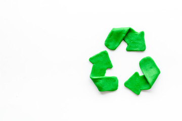 Recycling symbol - green arrows - on white background top-down copy space