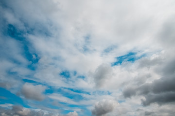 Blue sky with white soft clouds. Pleasant warm summer weather.
