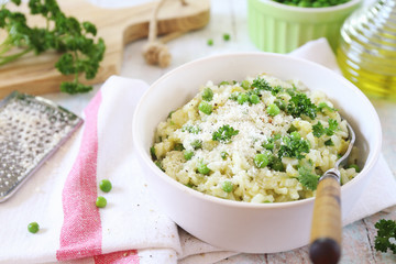 Italian cuisine. Plate of green pea risotto with green pea, parmesan cheese, olive oil and parsley