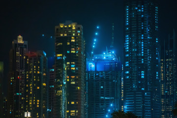 Modern business skyscrapers at night, high-rise buildings in Dubai.