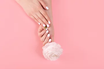 Foto op Plexiglas Handen van een mooie vrouw op een kleurrijke achtergrond. Delicate handpalm met natuurlijke manicure, schone huid. Licht roze nagels. © Ксения Овчинникова