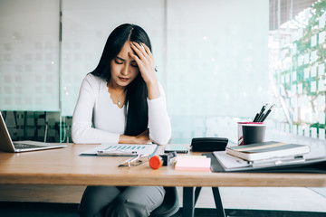 businesswoman sitting at table in office feeling tired and stressed when investment loss, investment concept, success concept
