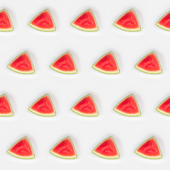 Red watermelon slices on sticks. Pattern on white background. Creative food concept. Flat lay.