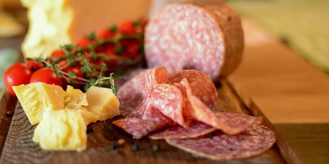 Assortment of salami sausage and cheese parmezan. Salami, sausages and cheese with cherry tomatoes.