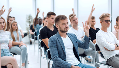 casual young man sitting among the seminar listeners