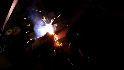 Welding in the dark with bright sparks close up 4k - Powered by Adobe