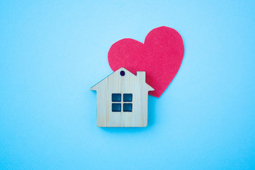 Love home, insurance and mortgage, marriage and valentine concept. Small wooden house toy and paper...
