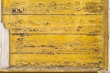 Old yellow wooden wall with cracked paint layer. Horizontal wooden planks detailed grunge texture.