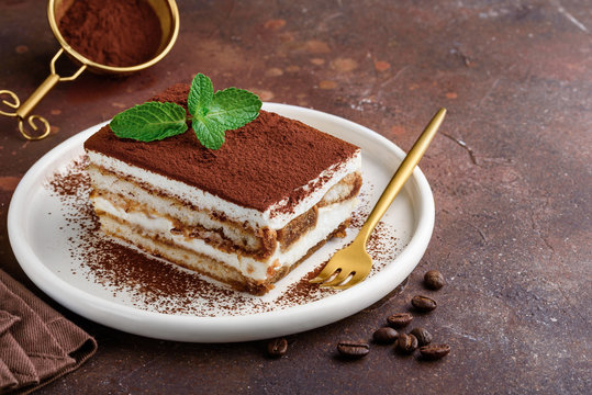 Traditional italian dessert tiramisu on a white plate. Copy space. Selective focus