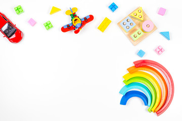 Baby kids toys background. Wooden educational geometric stacking blocks toy, rainbow, airplane, car and colorful blocks on white background
