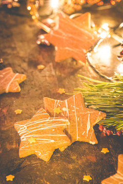 Homemade christmass cookies. Star shaped gingerbread cookies on a wooden background. Star decorations with greenery.
