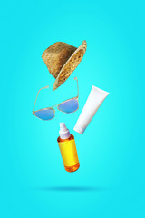 Flying objects, sunscreens. Hats, sunglasses, oil, cream with SPF. Concept of summer holidays, parties