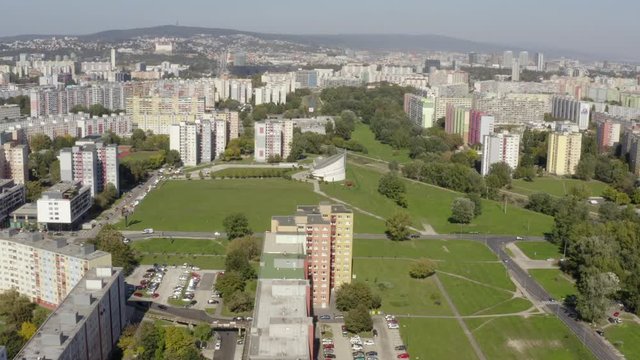 Aerial drone shot in Bratislava, Petrzalka showing comparison and contrast. Buildings vs. greenery with a modern church. Flying forward above houses to a topshot. Mavic2pro 25fps ProRes422