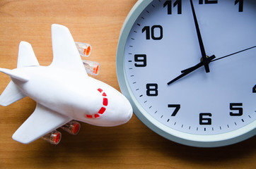 Analog clock and passenger plane. A toy airplane next to an analog clock. View from above.  On the clock 20:00, 08:00