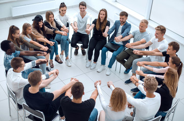 group of diverse young people putting their hands togethe