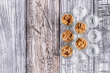 Fototapeta na wymiar Top view walnuts in jars with copy space on wooden background horizontal