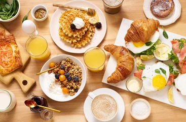 Fotobehang Top view image of brunch menu on wooden table. Healthy sunday breakfast with croissants, waffles, granola and sandwiches. Flatlay with tasty food © Anastasiia Nurullina