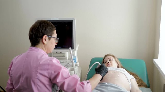 Process of ultrasonography, doctor checking baby in happy pregnant woman belly, modern medical technology
