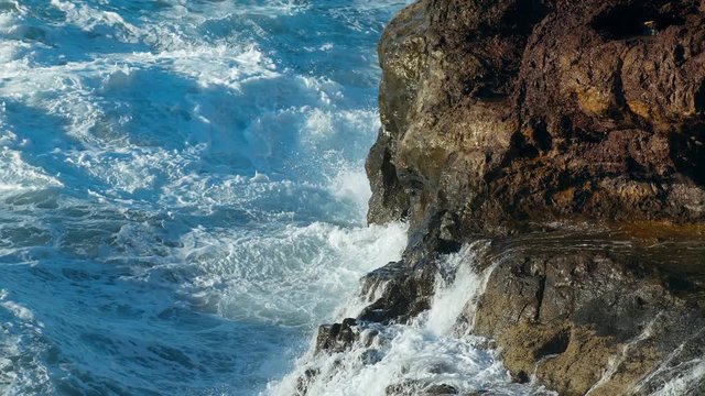 Storm in the Pacific Ocean Waves Break the rocks of the shore Water turns into Foam Droplets and Splashes Clear Blue water of the Sea. Gale Tide is playing with the Sun shot slow motion URSA 4.6K