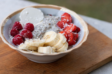Chia seed pudding with berries Milk yogurt cream strawberries raspberries bananas coconut flax seed oatmeal in a bowl. Clean and balanced healthy food concept, healthy, vegetarian or super food concep