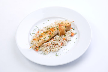 chicken kebab with barley on the white plate