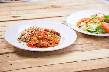 meat with buckwheat and salad on the wooden background