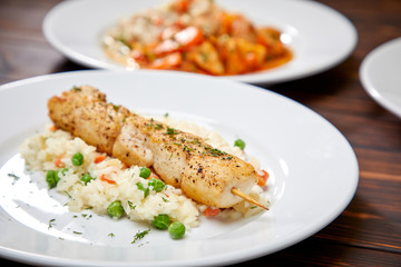 chicken kebab with rice and vegetables on the wooden background