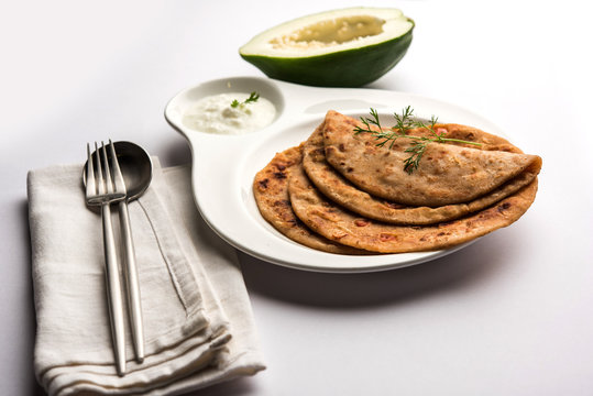 Raw Papaya Paratha or Papita ke Parathe made using Made using papaya, wheat flour, cumin seeds, ginger. Popular Indian food recipe served hot with curd. selective focus