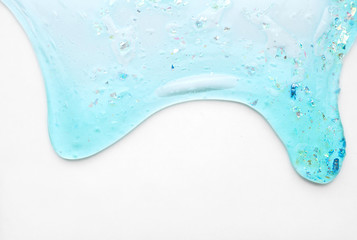 Blue slime with sparkles and oxygen bubbles flows down on a clean white background for the...