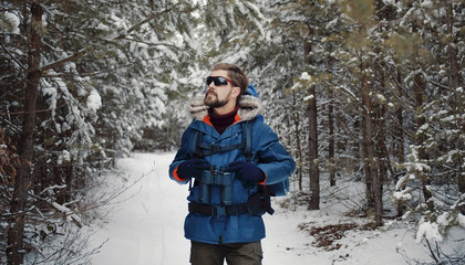 Front view of mature bearded man walking through forest enjoying winter nature, half-body image © MYDAYcontent